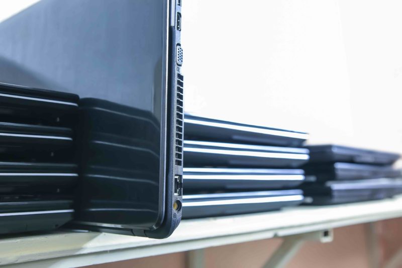 a stack of old laptops on a shelf