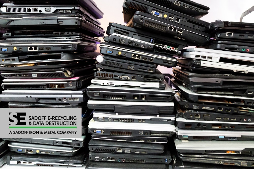 Old laptops in a pile and Sadoff logo