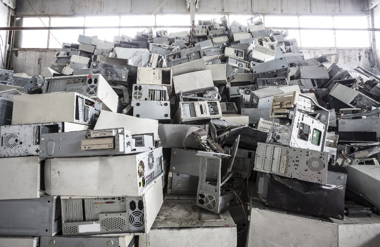 Computers piled up in a warehouse space