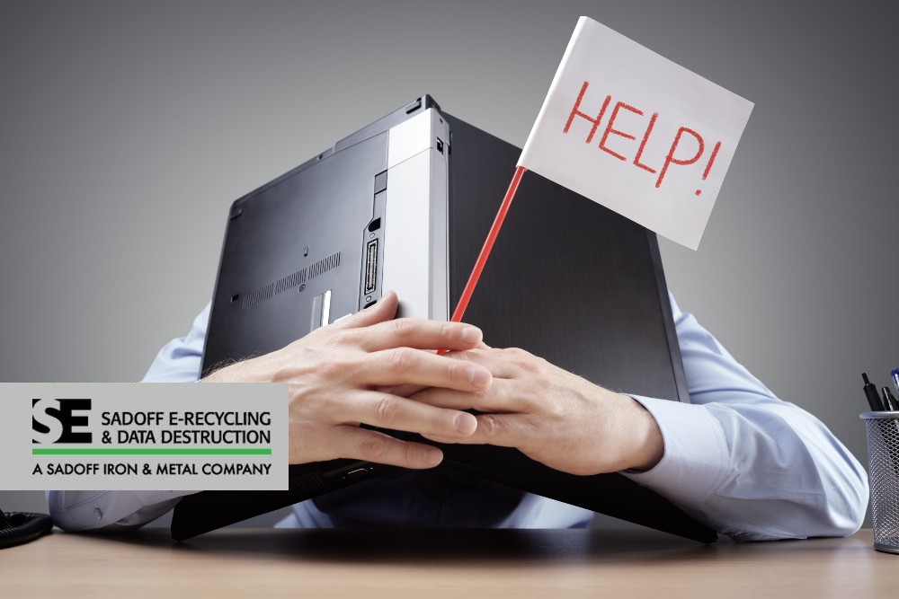 Man holding laptop over his head with a help sign and Sadoff logo