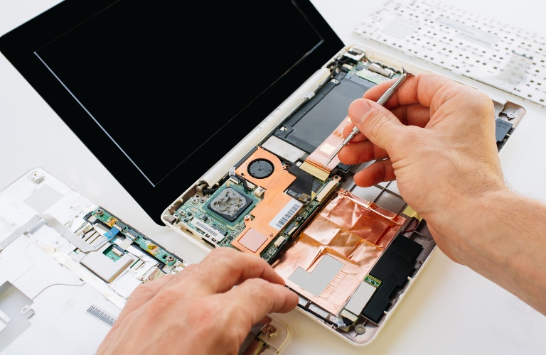 Person working on a laptop's internals