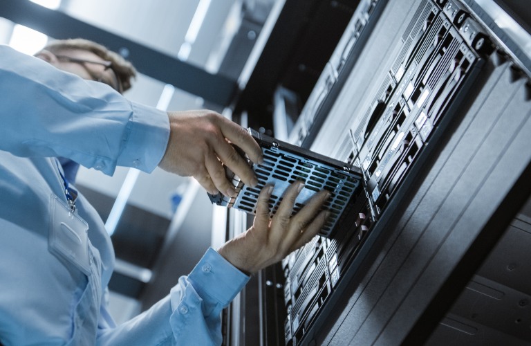 Man taking drive out of server bank