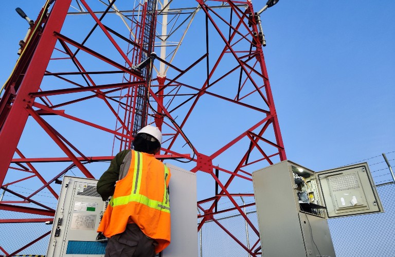 Worker operating telecom equipment outdoors