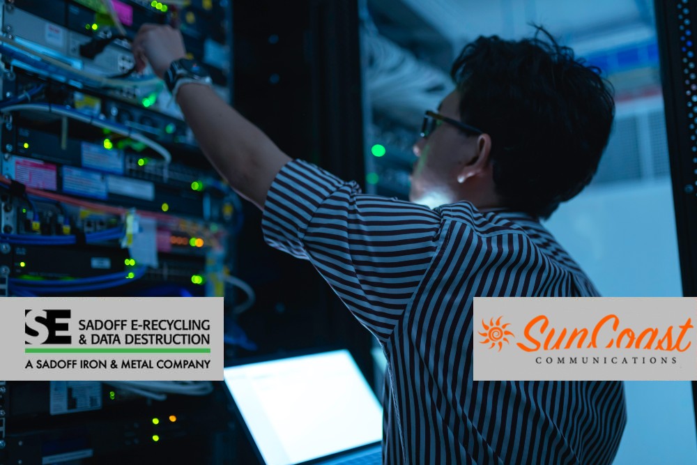 Man working in a data center with laptop with Sadoff and SunCoast logo