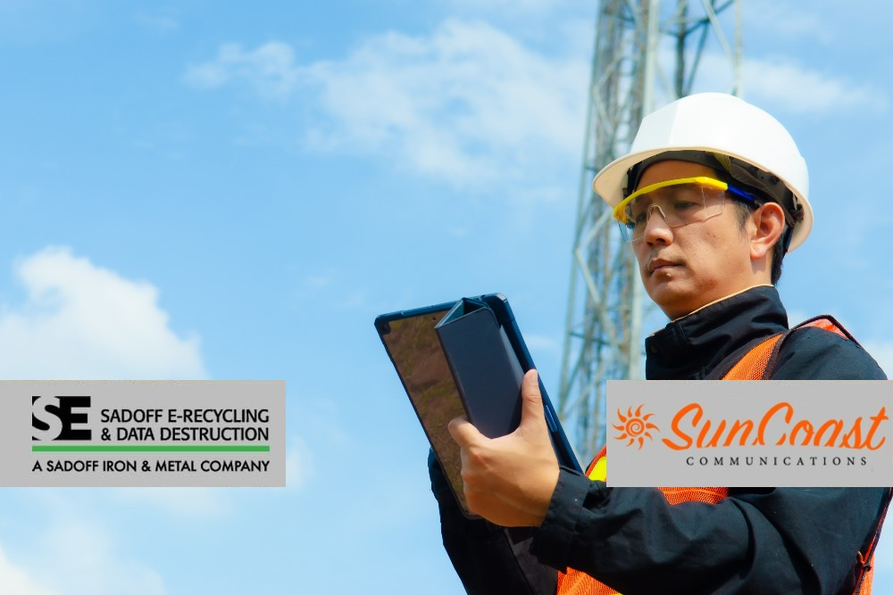 Man working with tablet infront of cell tower with Sadoff and SunCoast logo